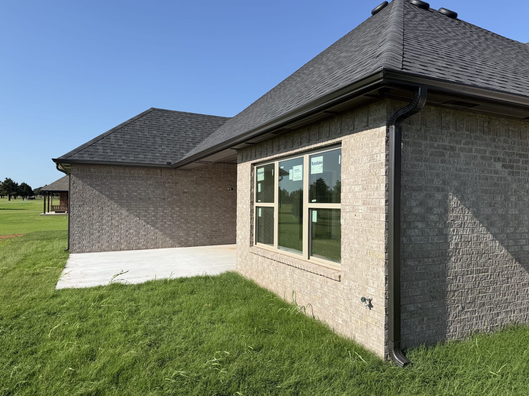 Seamless gutters along the patio side of a brick home in Oklahoma City, OK